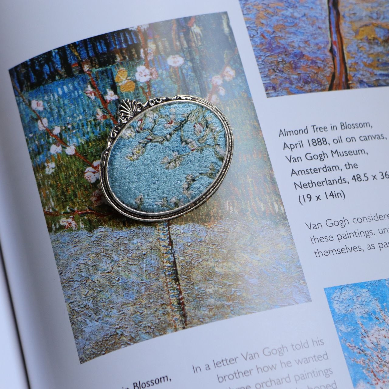 Hand embroidered brooch inspired by Vincent van Gogh's flowering branches, featuring white blossoms against a blue sky, handcrafted textile jewelry and wearable art by Mina.