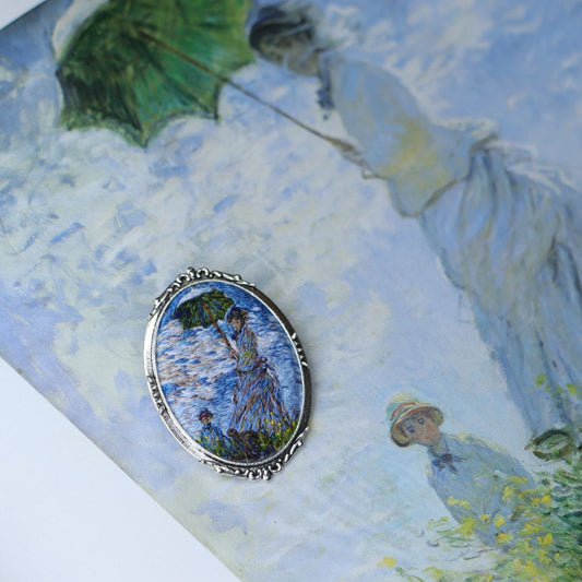 Hand embroidered brooch inspired by Claude Monet, featuring a woman with a green parasol in an Impressionist landscape, handcrafted textile jewelry and wearable art by Mina.